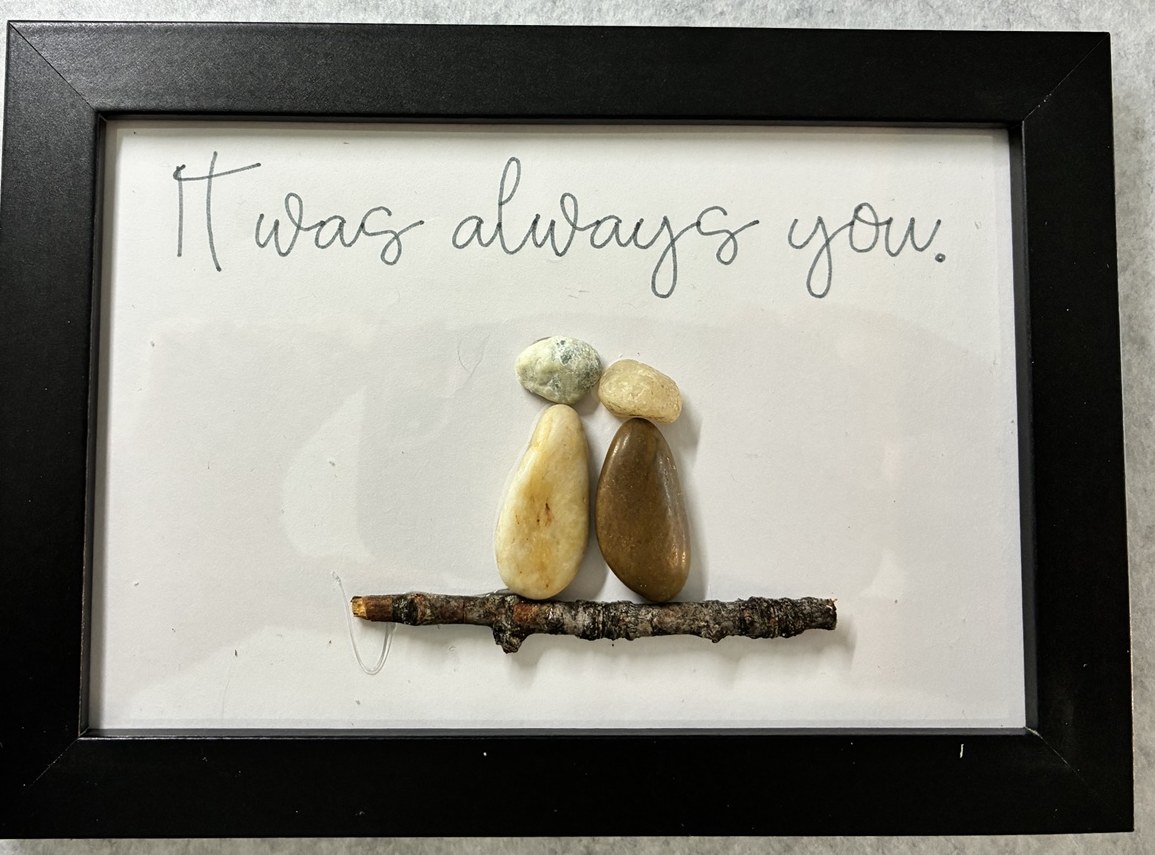 A pebble couple standing together on a twig beneath It was always you