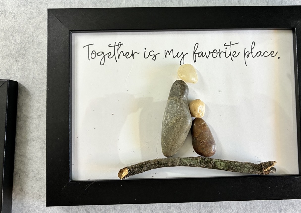 Two pebble figures leaning together on a twig beneath Together is my favorite place